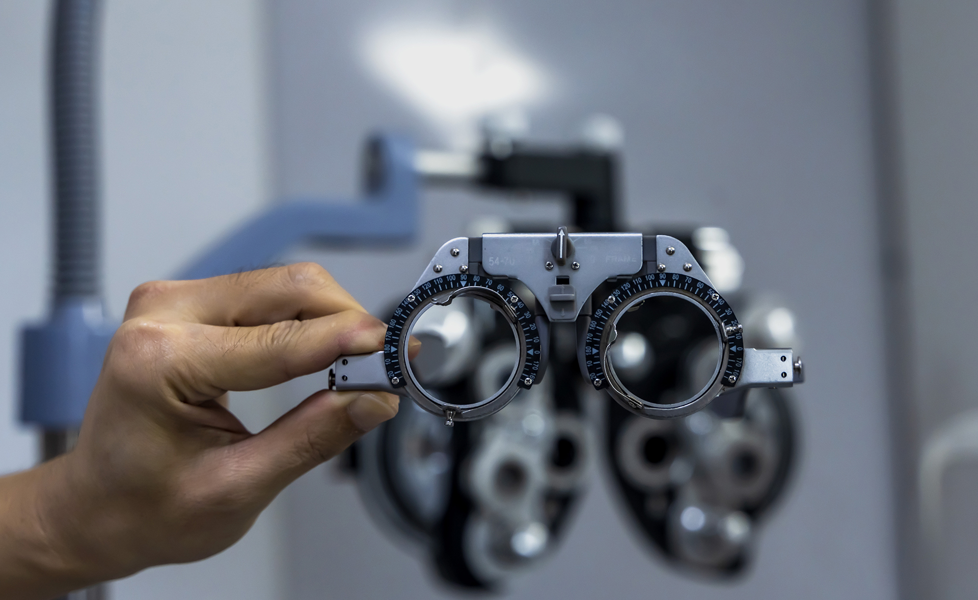 Close up optician hand adjusting Phoropter