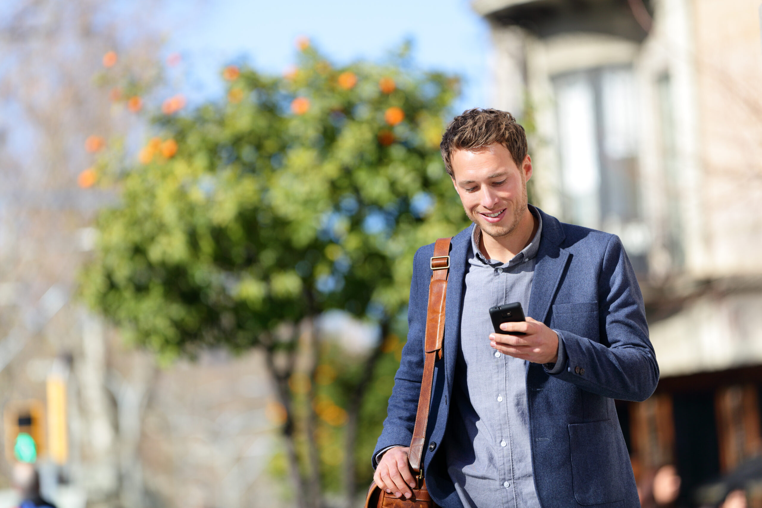 Urban professional checking his phone outside